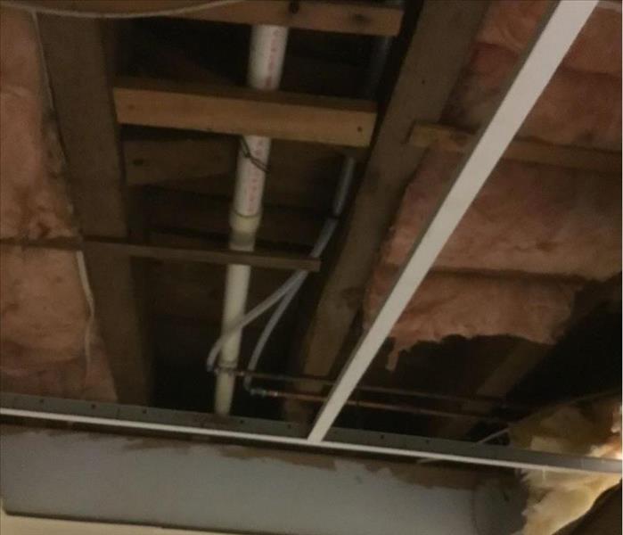 Open ceiling and pipes with water damage